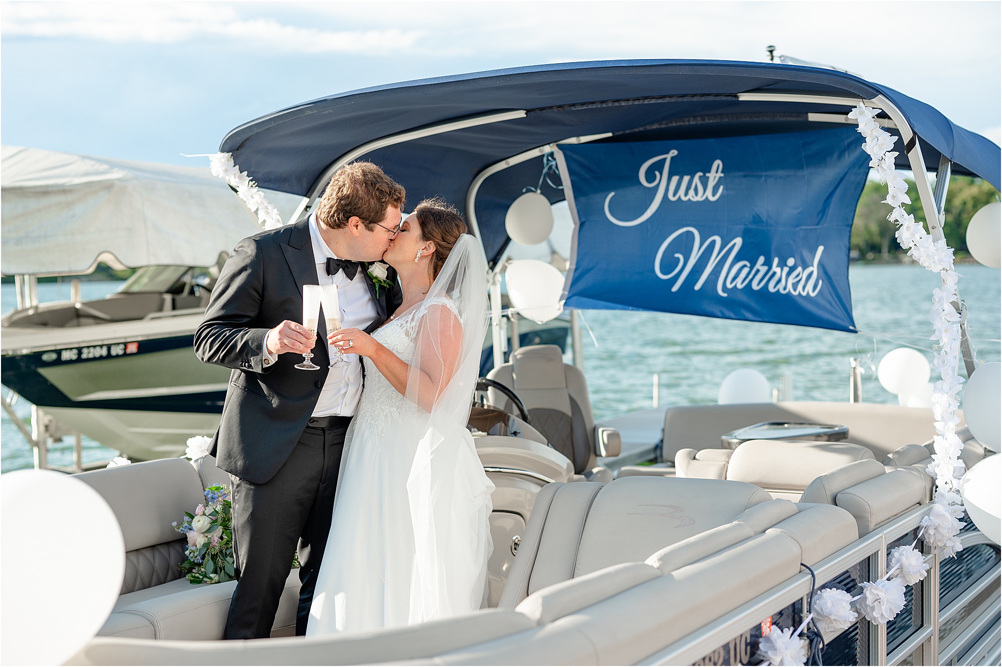 Lauren and Ben kiss on a boat decorated with a "Just Married" sign.