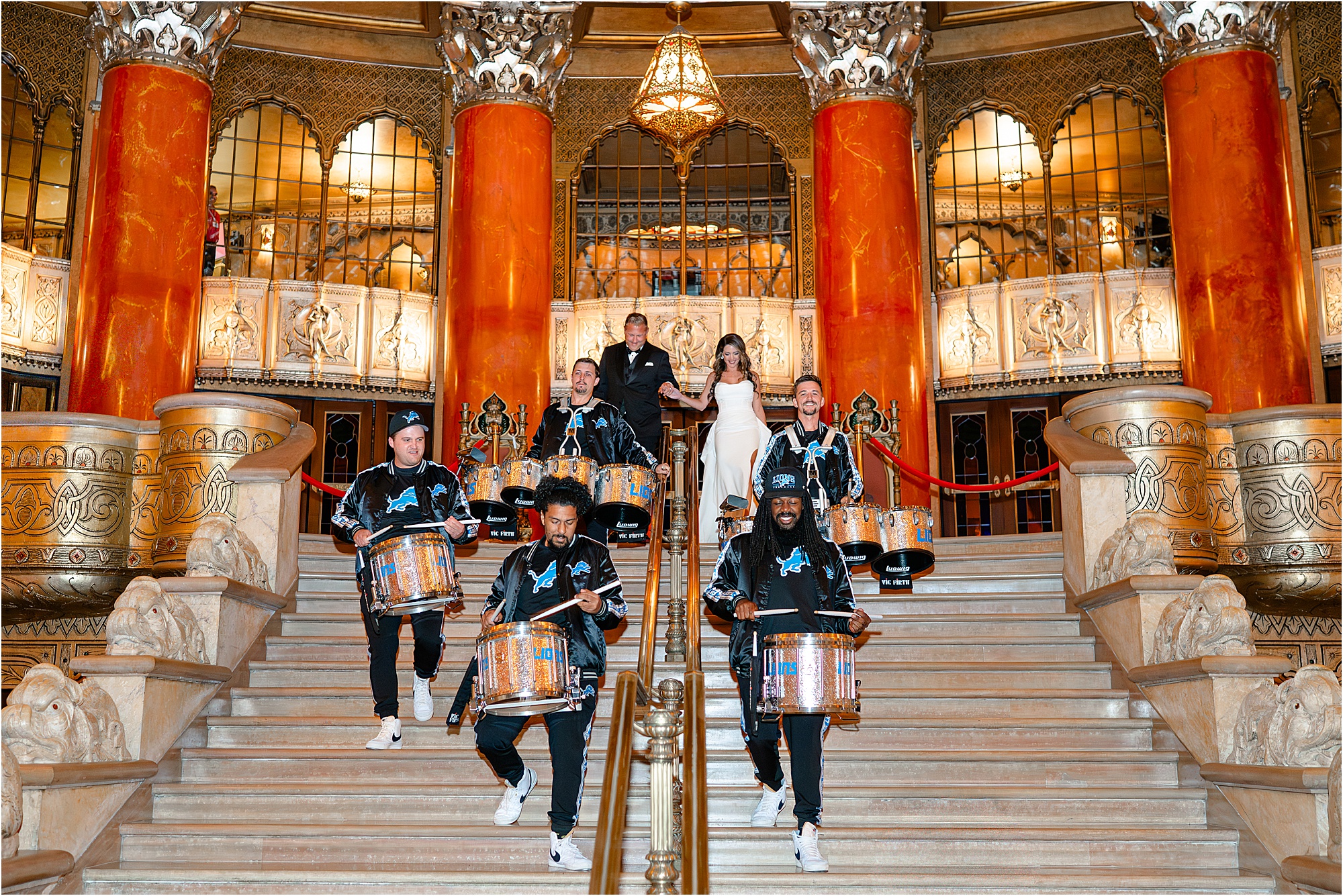 On their wedding day, Sunshine and Jeff descend down the grand staircase at the Fox Theater behind the Detroit Lions Drumline, the Honolulu Boom.