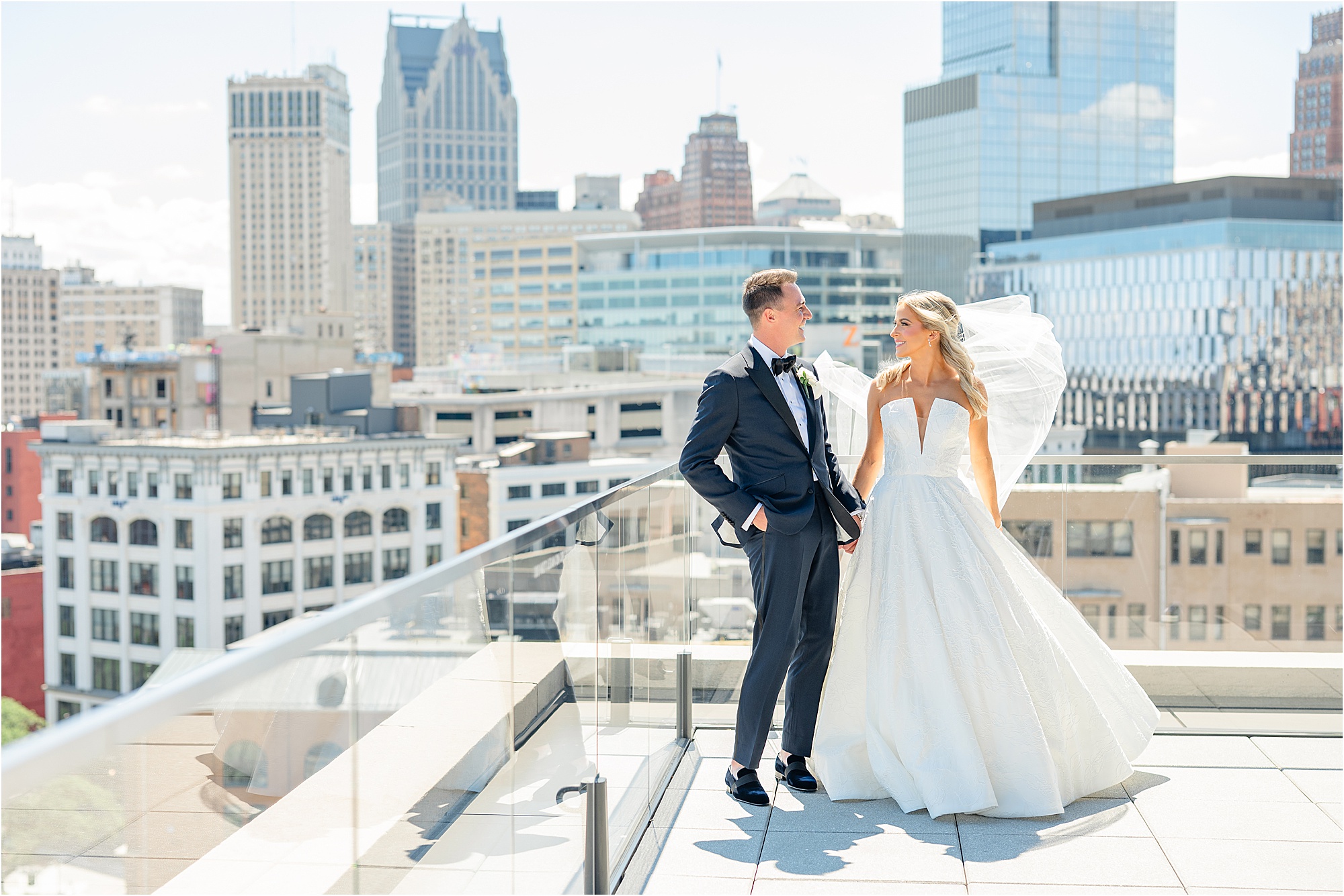 Trina and Dan laugh at each other on the Detroit Athletic Club rooftop on their wedding day, overlooking downtown Detroit.